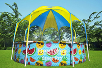 Children's pool with colorful fruit and smiley face design on a grassy area with trees in the background.