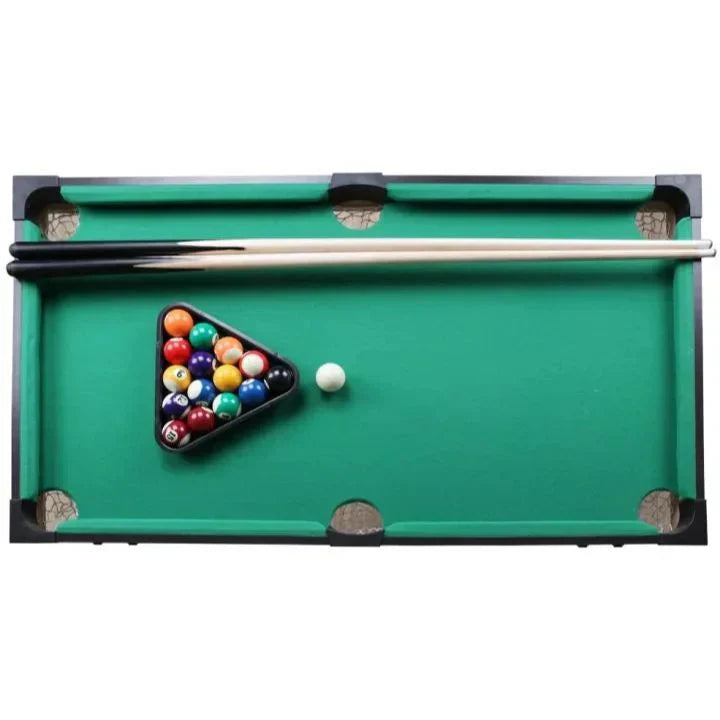 Miniature pool table with balls and a cue on a white background