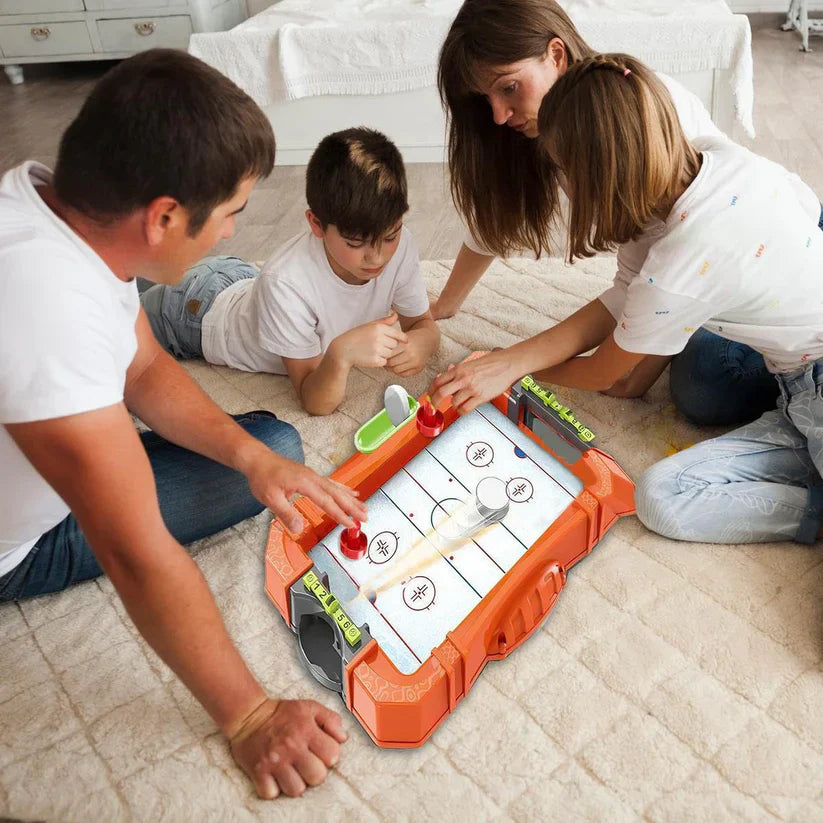 Family playing with a toy hockey set on the floor