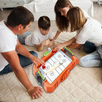Family playing with a toy hockey set on the floor