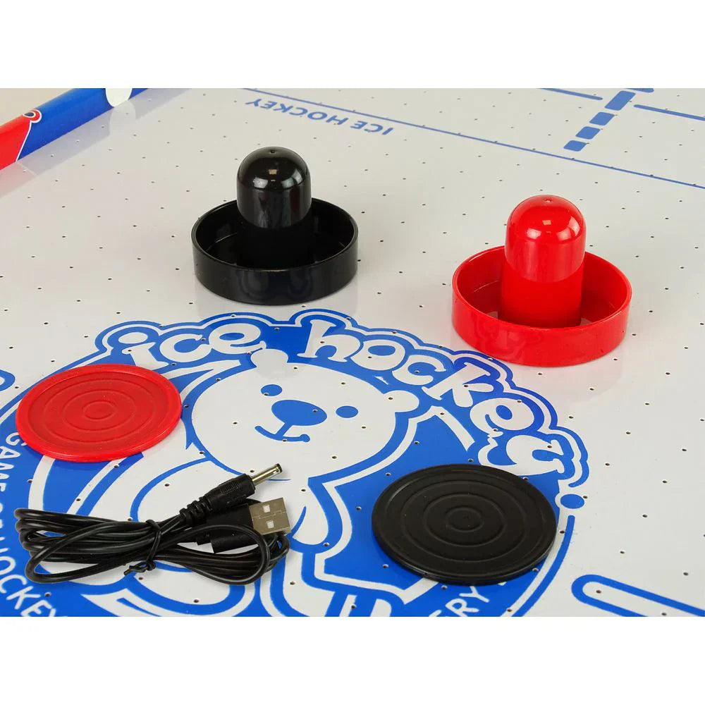 Close-up of hockey pucks and a USB cable on an ice hockey game board.