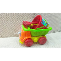 Colorful toy set with a red bucket, green shovel, and orange sandcastle mold on a textured surface.