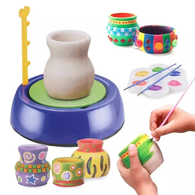 Children's pottery wheel with painted ceramic cups and a hand holding a paintbrush.