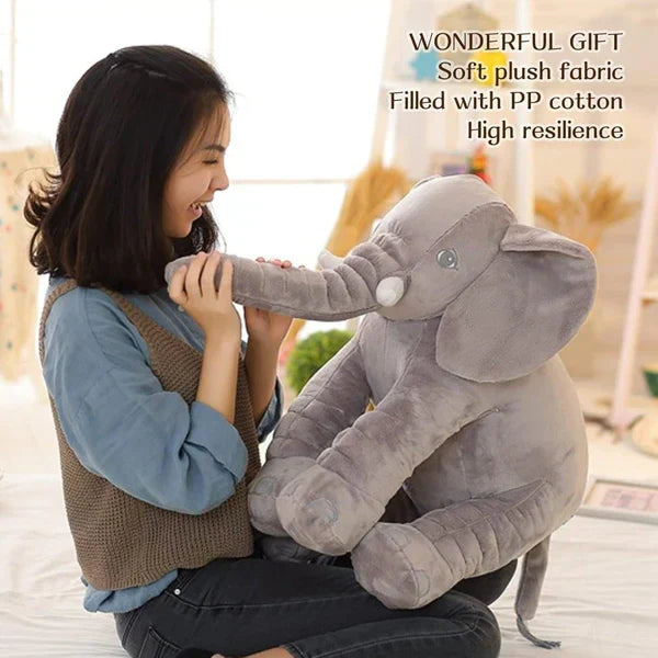 Woman holding a large plush elephant toy with text about its features.