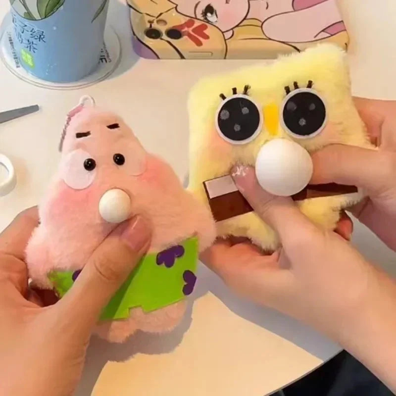 Two plush toys, one pink and one yellow with a chocolate bar, held by hands on a colorful background.